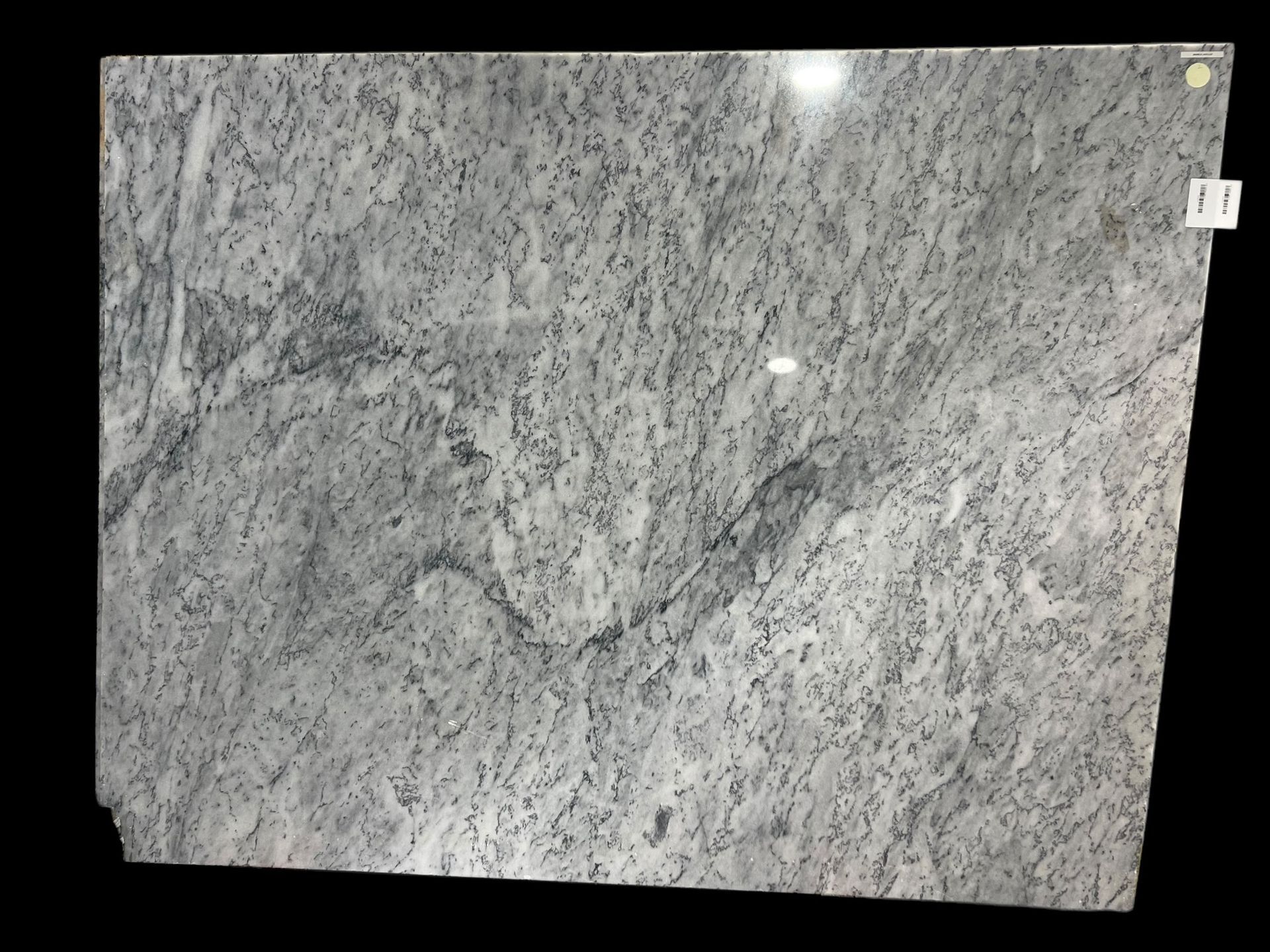 A close up of a white granite slab on a black background.