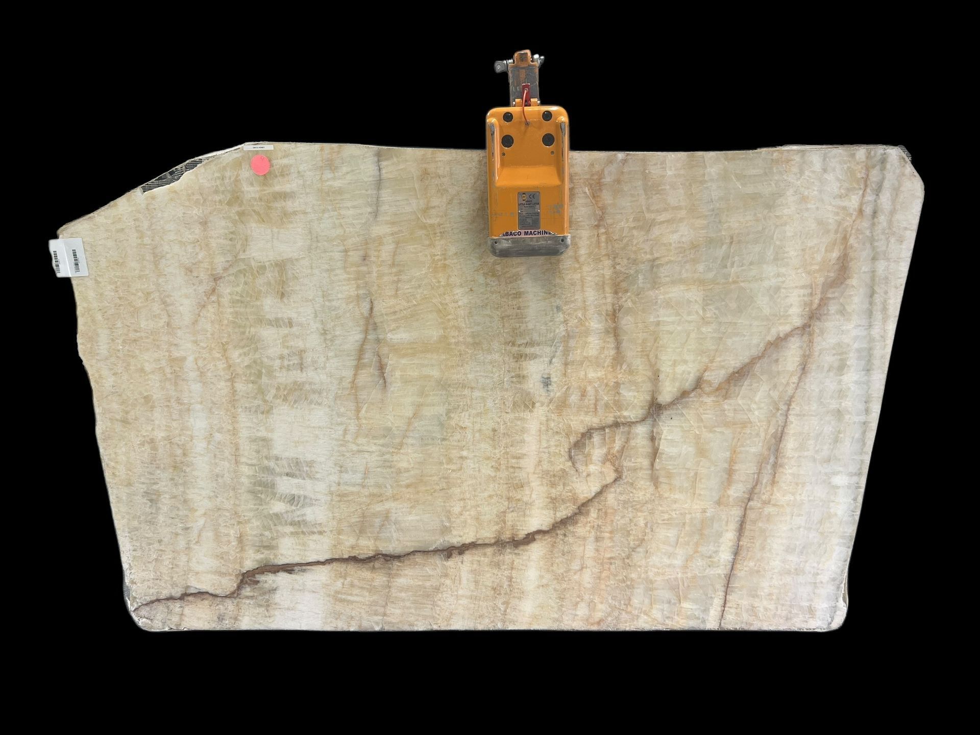 A large piece of stone is being lifted by a crane.