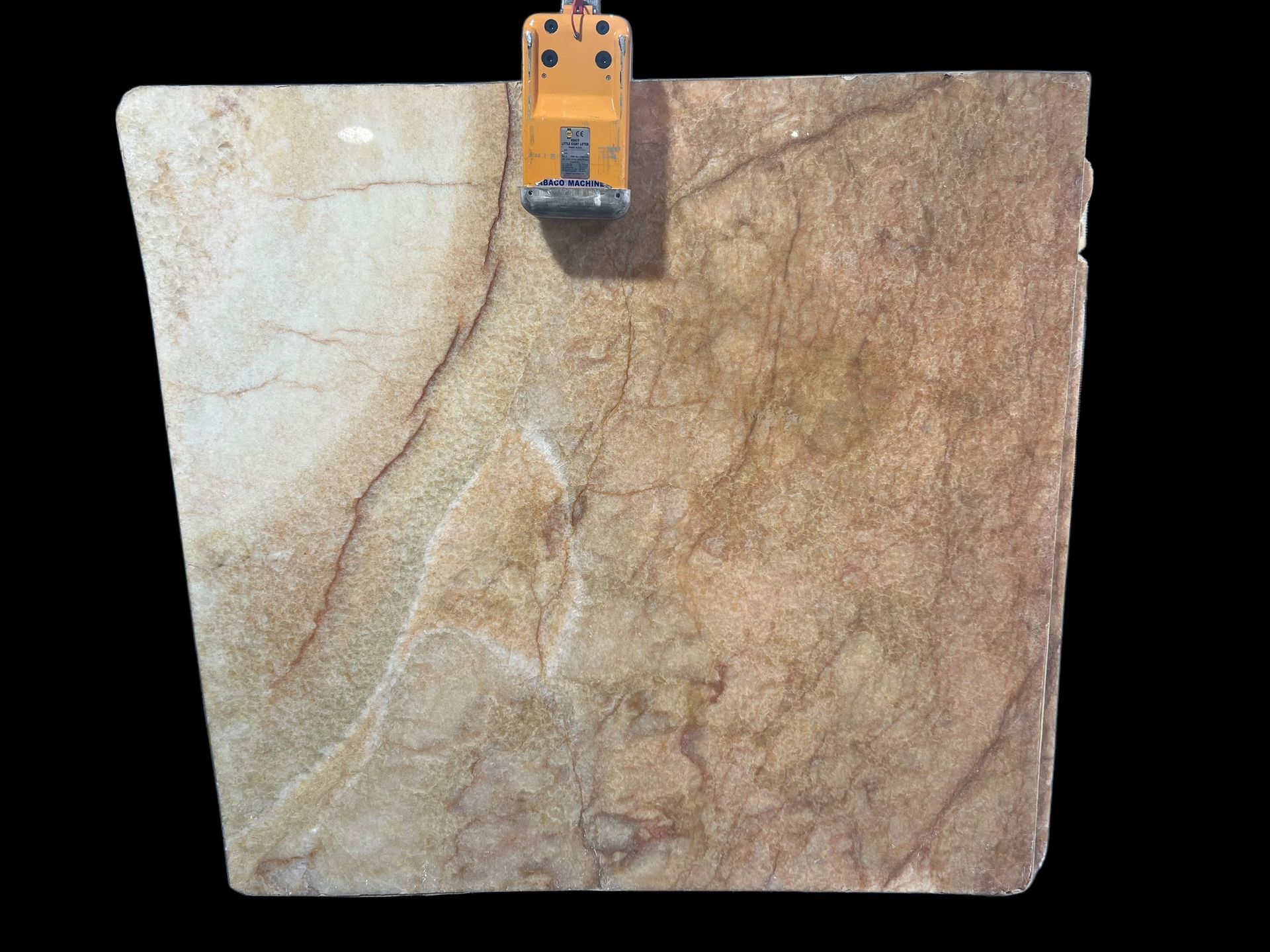 A piece of marble is hanging on a hook on a black background.
