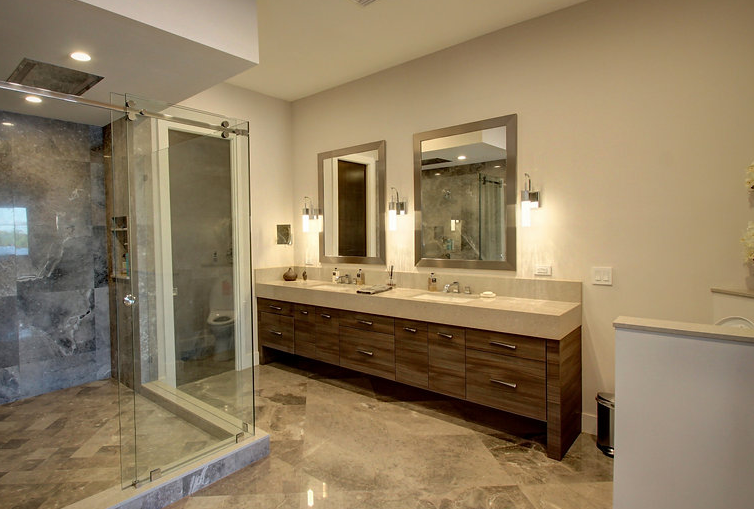 A bathroom with two sinks and a walk in shower.