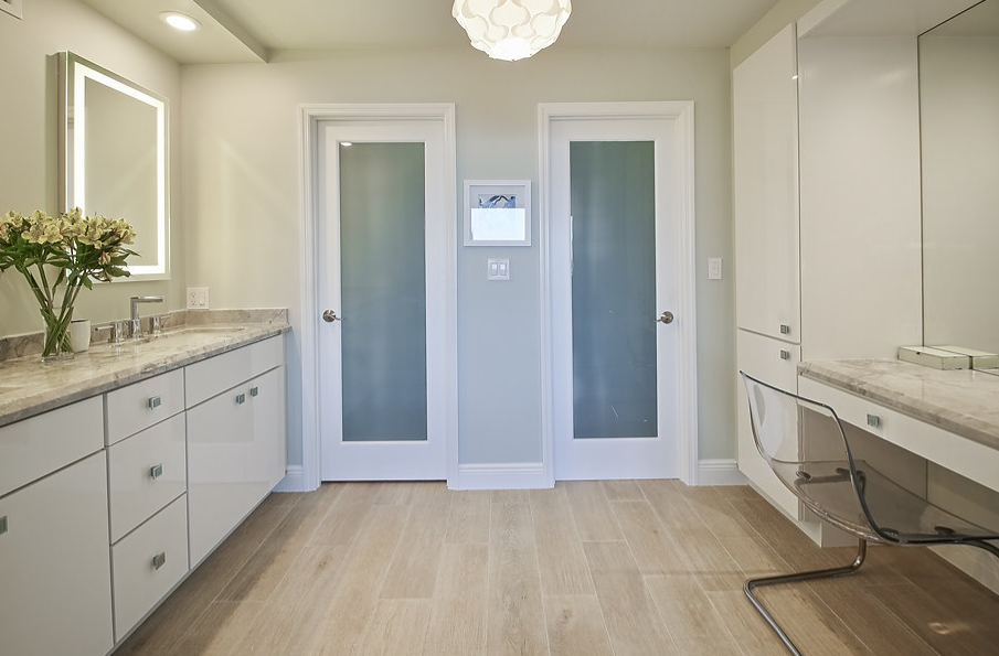 A bathroom with two sinks , a mirror and a desk.