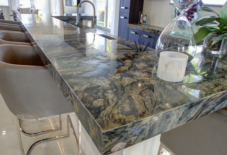 A kitchen with a granite counter top and stools.