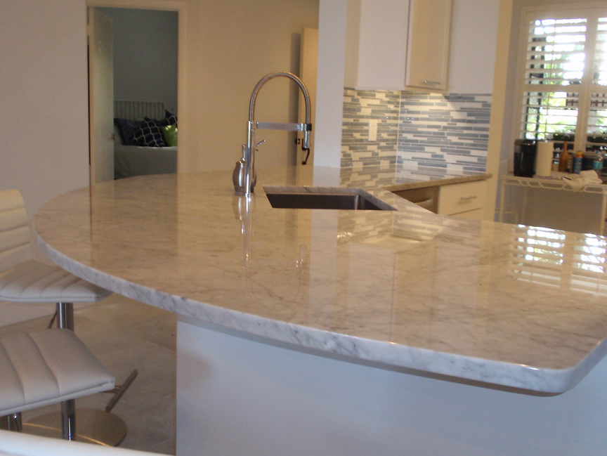A kitchen with a curved counter top and a sink