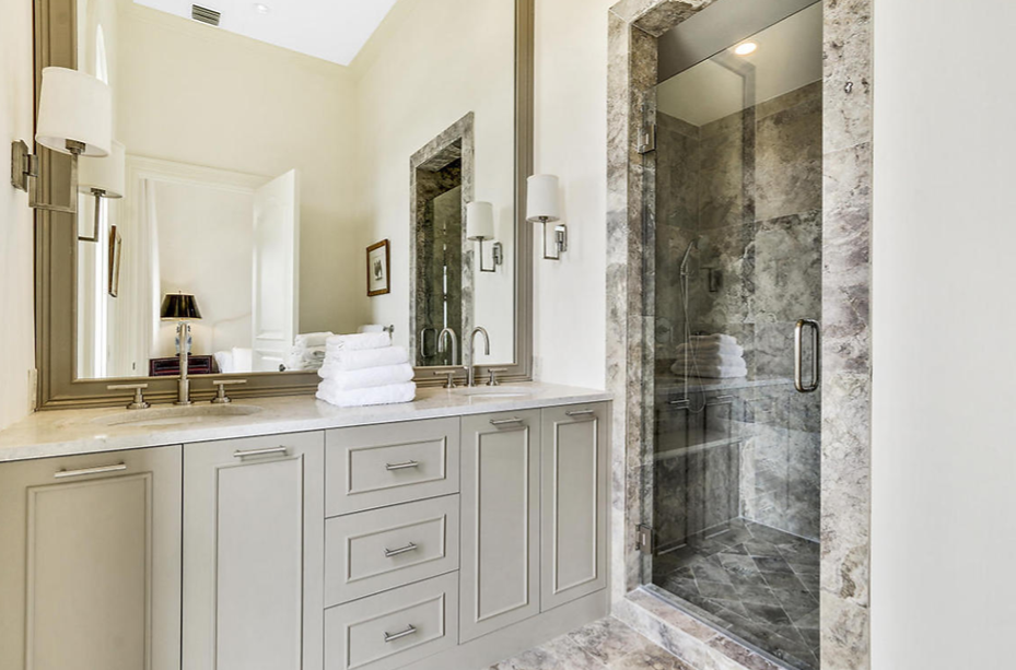 A bathroom with a sink , mirror , and walk in shower.
