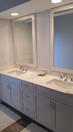 A bathroom with two sinks and two mirrors.