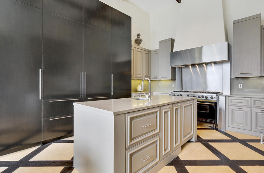 A kitchen with stainless steel appliances and a large island in the middle.