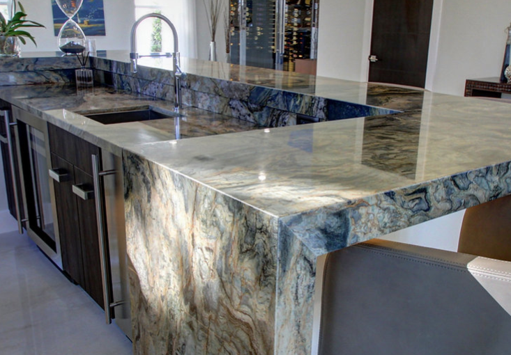 A kitchen with a large granite counter top and a sink.