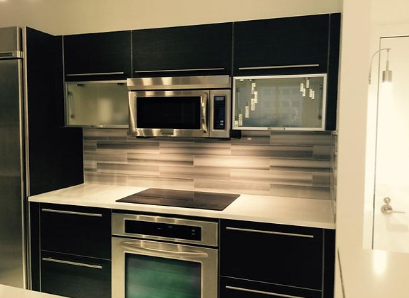 A kitchen with black cabinets and stainless steel appliances