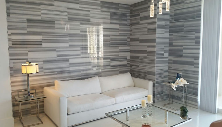 A living room with a white couch and a glass coffee table.