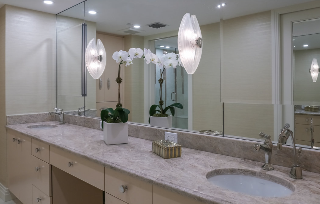 A bathroom with two sinks and a large mirror.