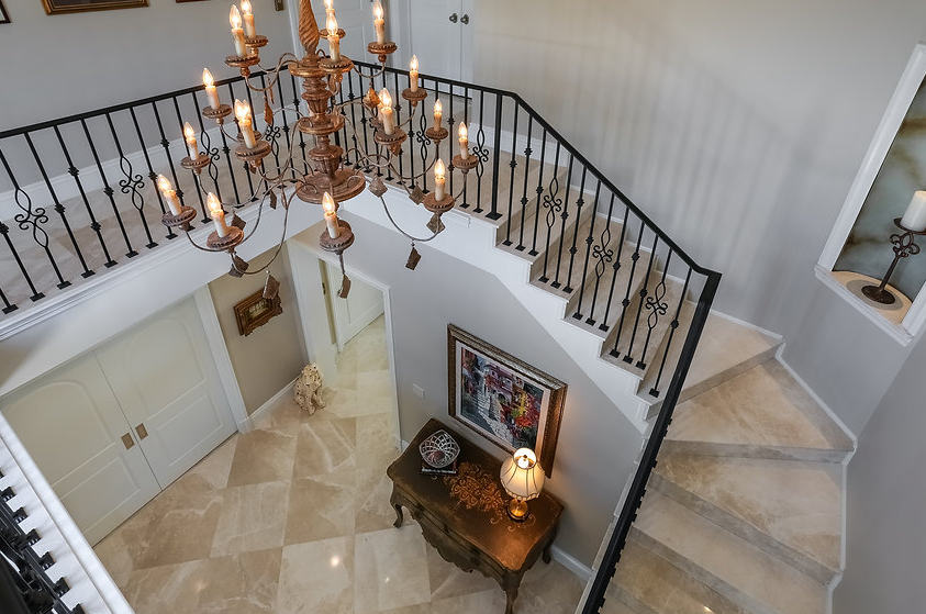 An aerial view of a staircase with a chandelier and a piano