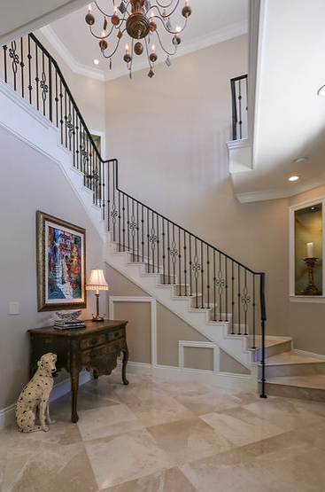 A staircase with a chandelier and a dalmatian statue