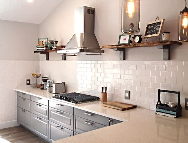 A kitchen with gray cabinets and white counter tops