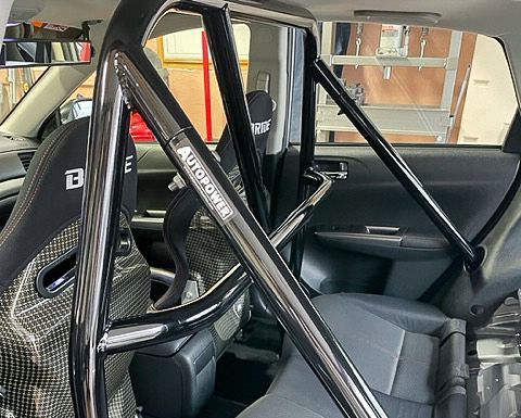 Black roll cage installed inside a car, visible with racing seat.