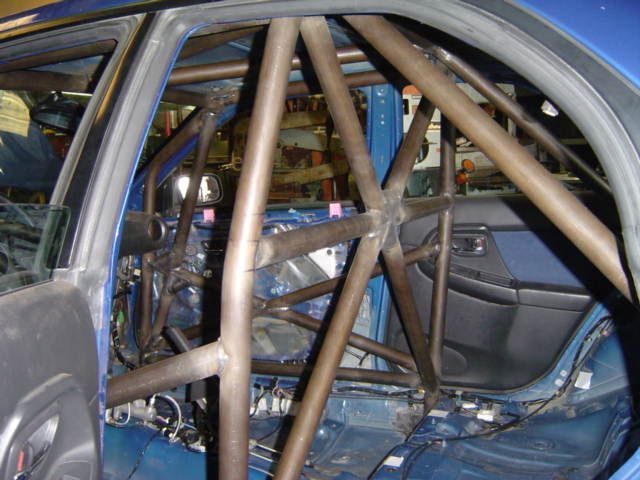 Blue car interior with a welded steel roll cage for safety.