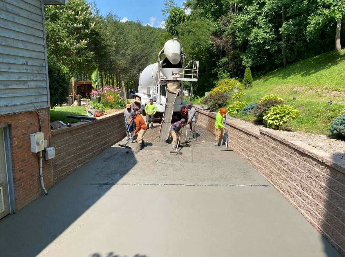 A concrete truck is pouring concrete into a driveway.