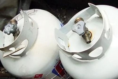Two white propane tanks with gray valves and protective collars.