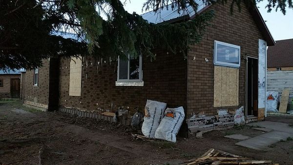 Brick building exterior under construction, some walls covered in siding.