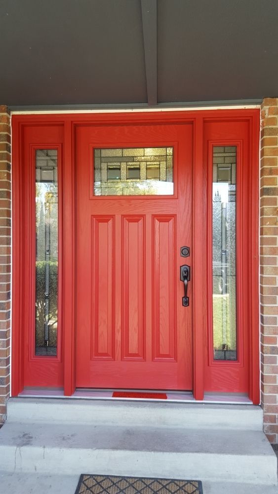 Red front door with sidelights, steps leading up.