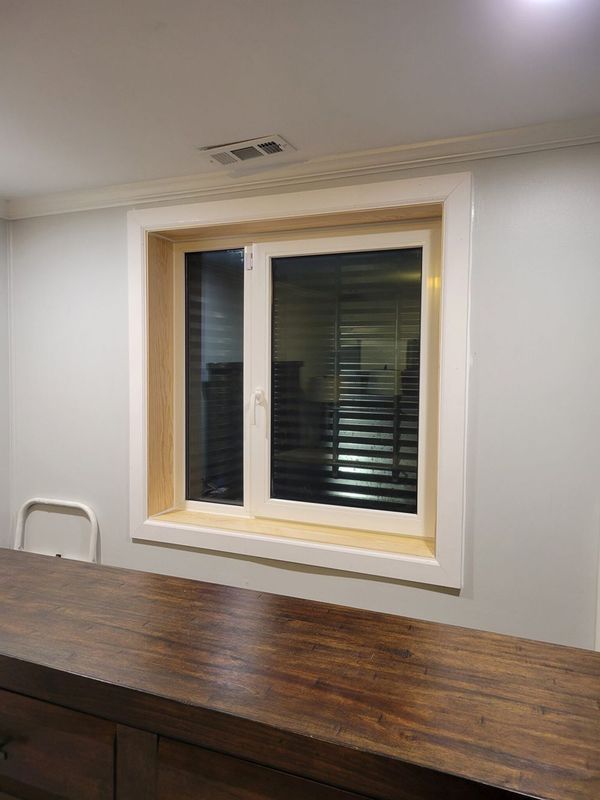 White-framed window in a gray-walled room, above a wooden counter.  A white chair is partially visible on the left.