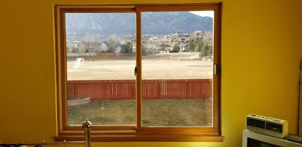 A sunny room with a sliding glass door offering a view of a mountain range.