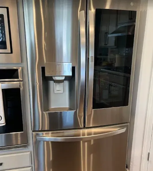 Stainless steel LG refrigerator with water/ice dispenser and door-in-door feature.
