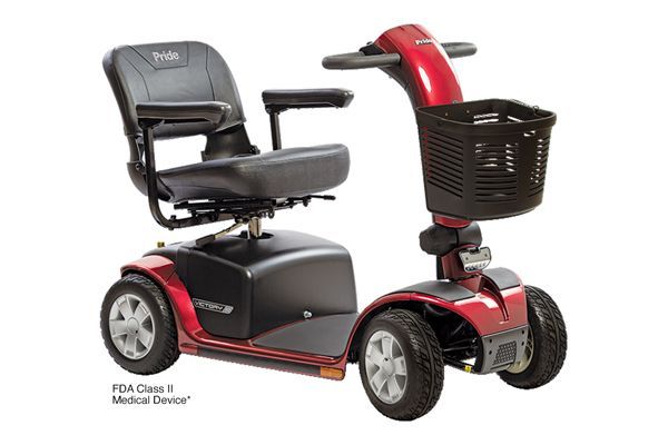 A red four-wheeled mobility scooter with a black seat, armrests, and a front storage basket on a white background.