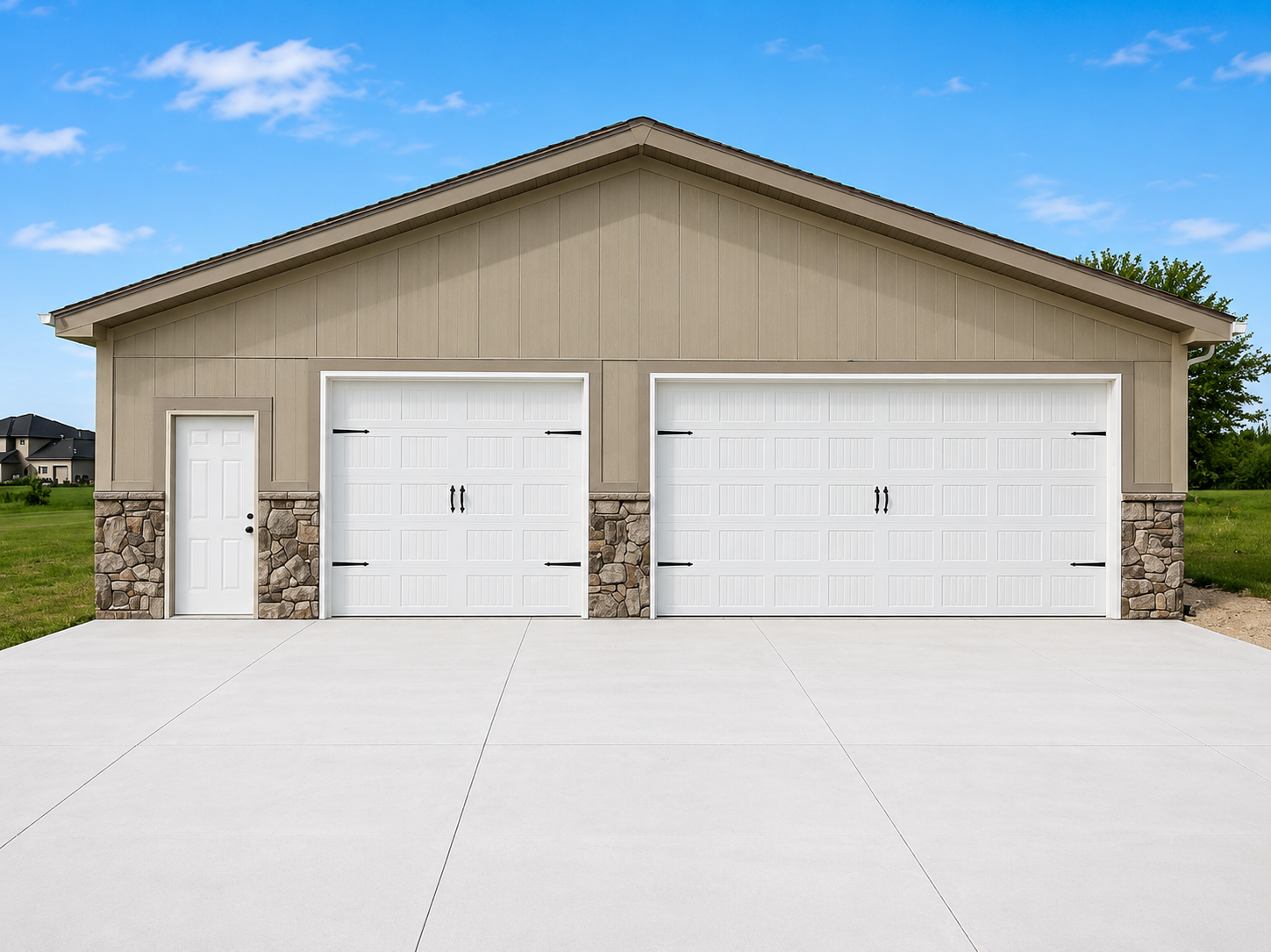 Beige garage with white doors and stone accents, set behind a wide concrete driveway.