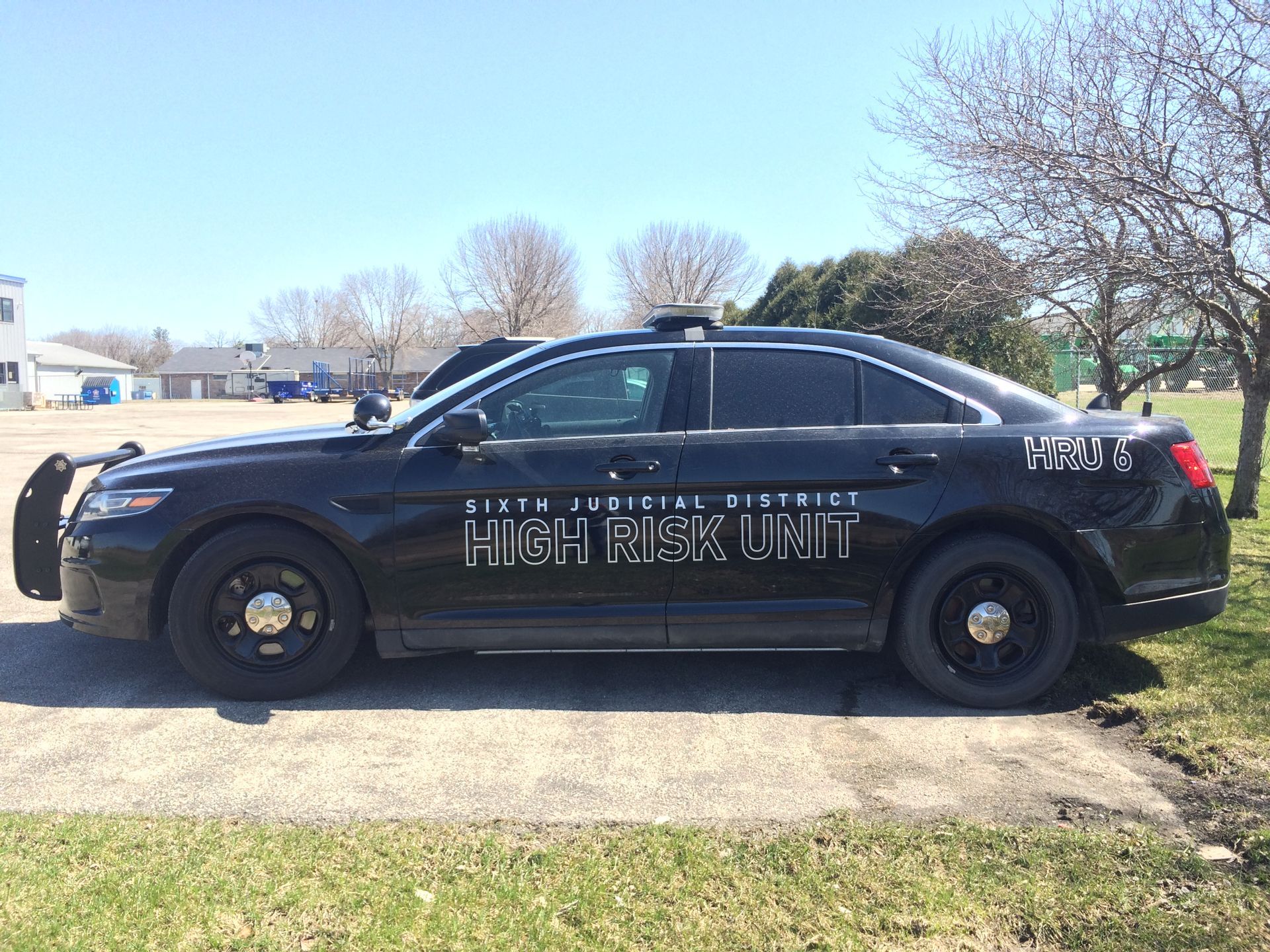 A black police car is parked on the side of the road.