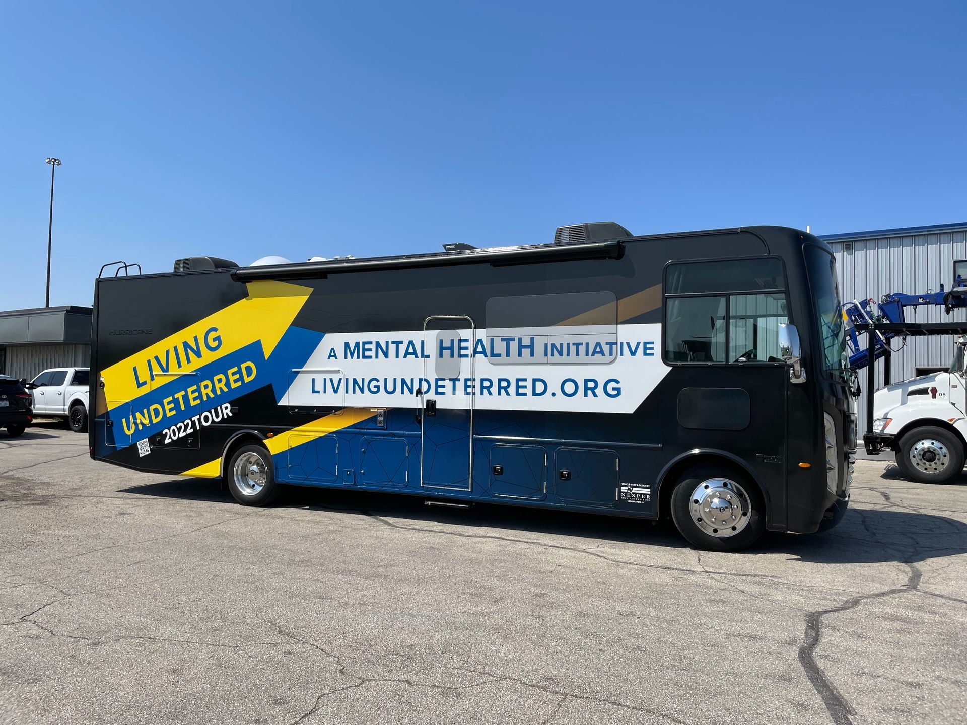 A blue and yellow bus is parked in a parking lot.