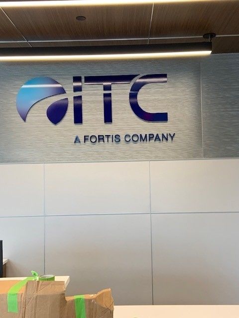 The ITC logo, a Fortis company, on a wall. The logo is blue and white with the text