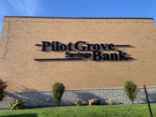 Pilot Grove Savings Bank building with black lettering on a tan brick exterior.