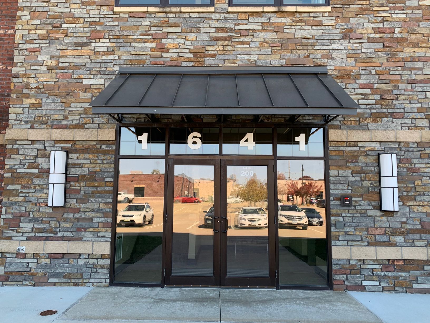 Building entrance with address '1641' above glass doors; brick and stone exterior.