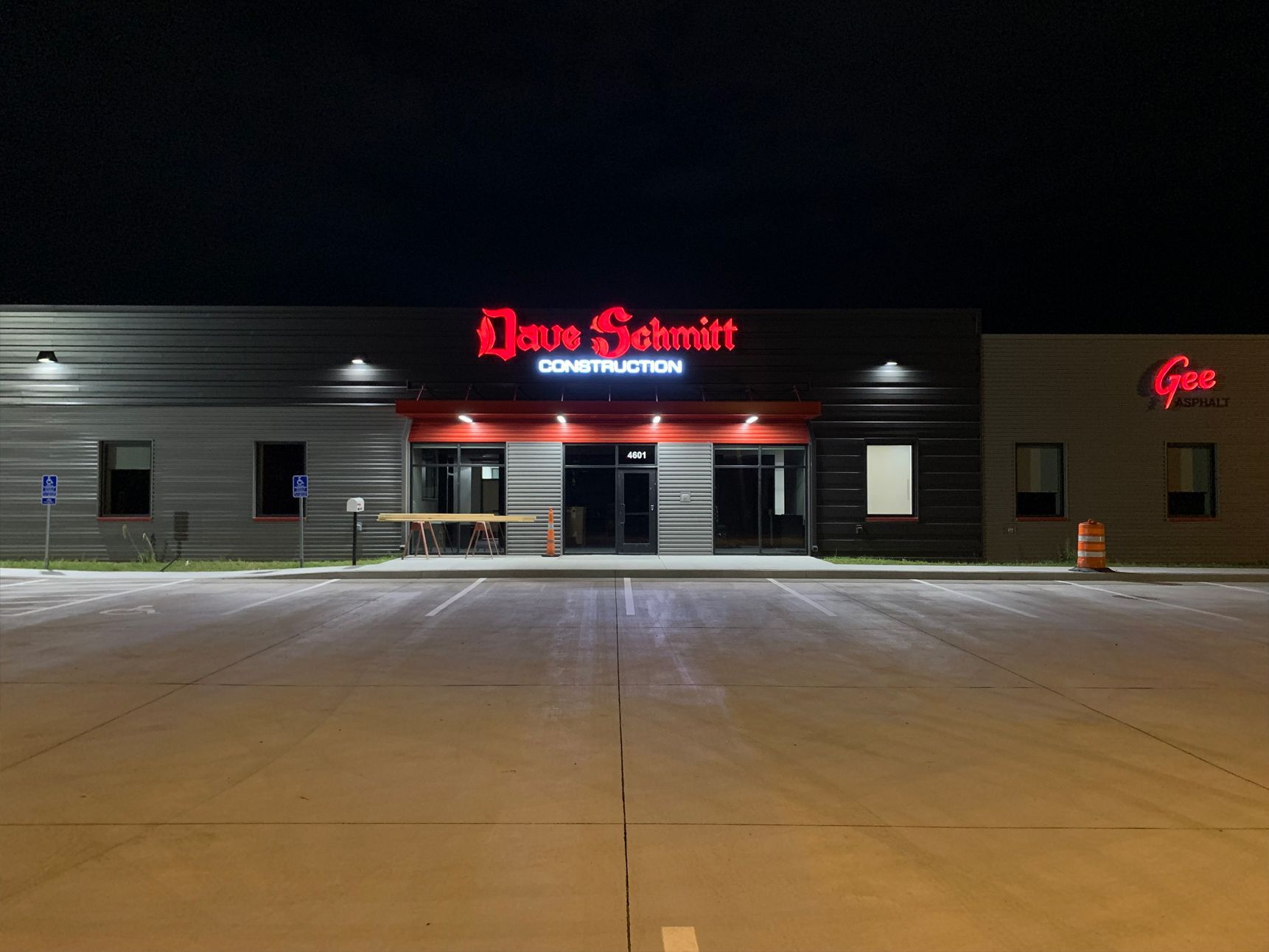 Night shot of Dave Schmitt Construction building with lit red sign above the entrance.