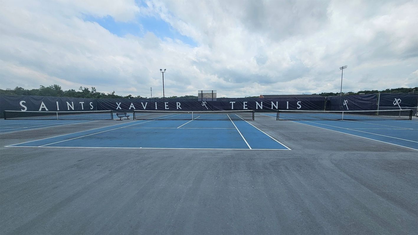 A tennis court with the words saints xavier tennis written on it