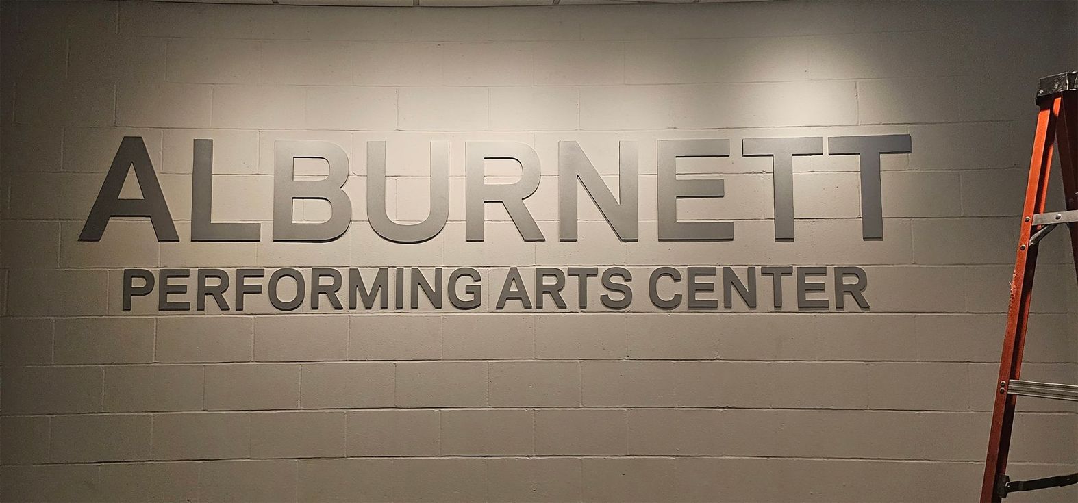 A sign for the alburnett performing arts center
