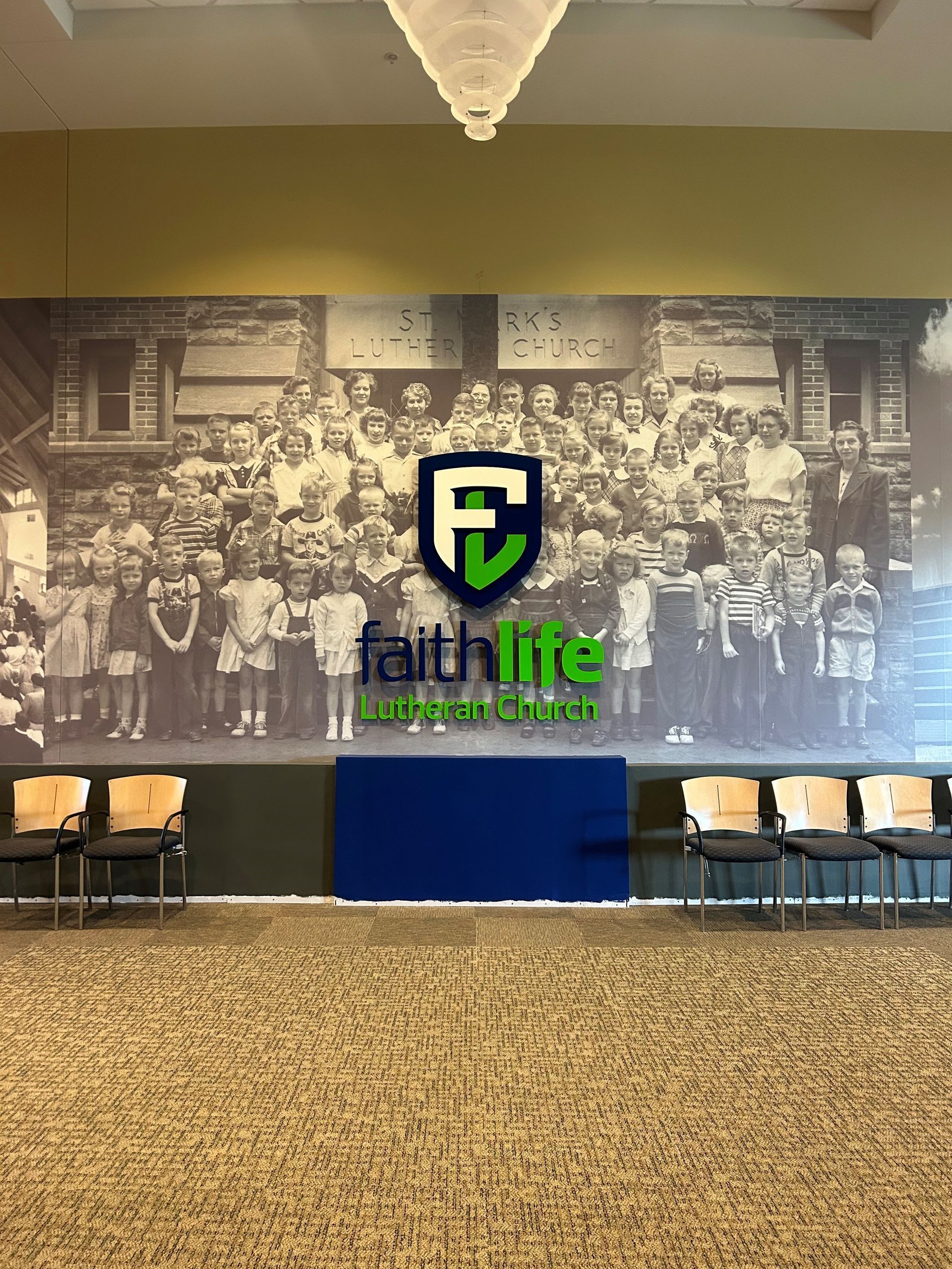 There is a large picture of a group of children on the wall.