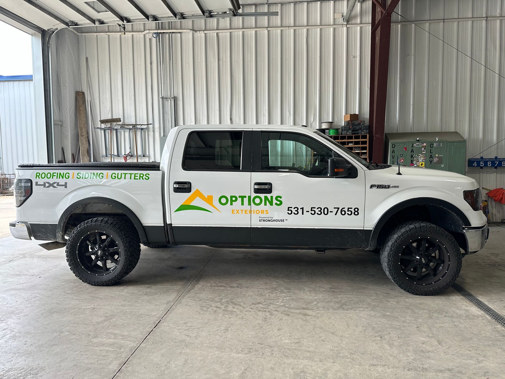 A white pickup truck is parked in a garage