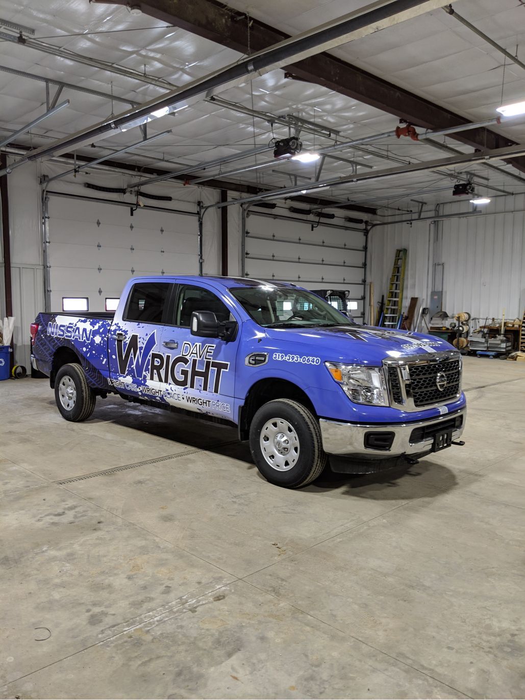 A blue truck is parked in a garage.
