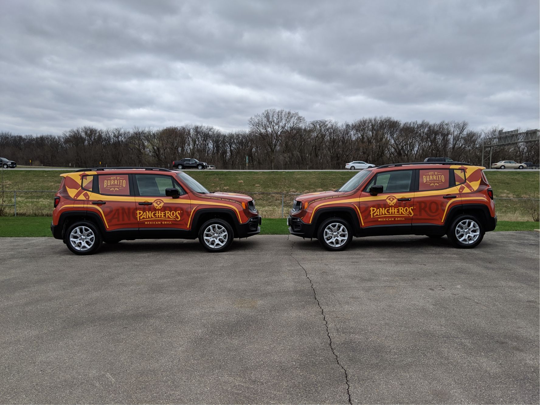 Two jeep renegade vehicles are parked next to each other on a concrete surface.