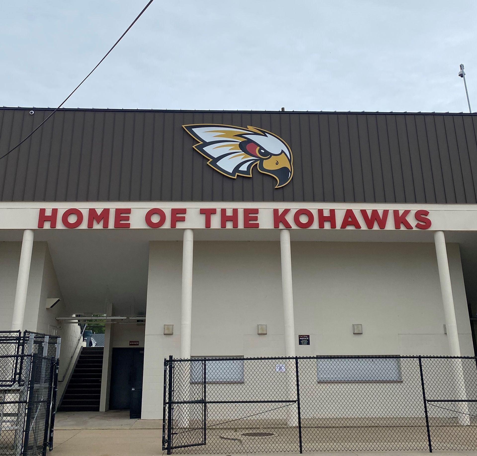 A white building with a sign that says home of the kohawks