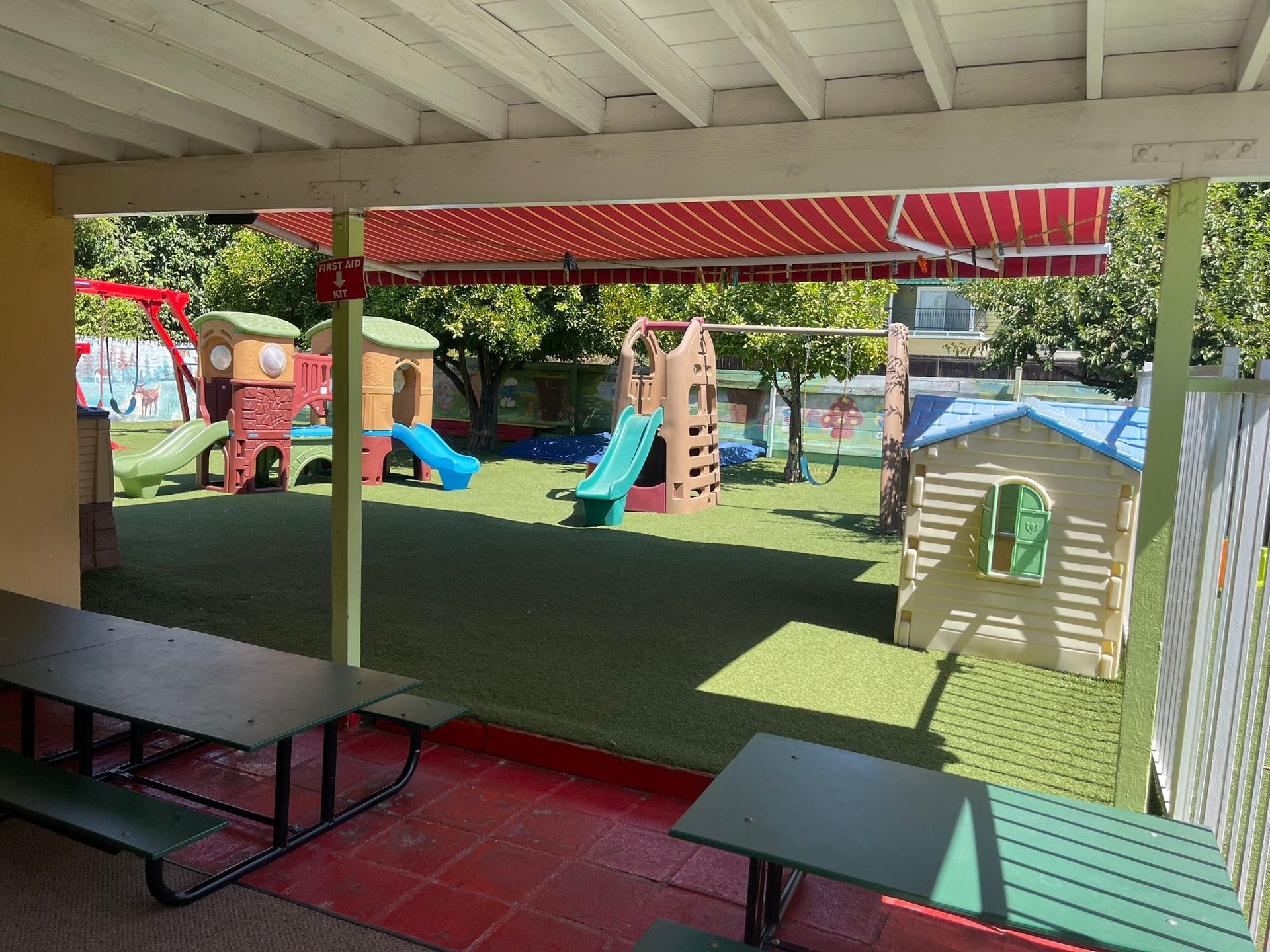 A playground with a table and benches and a slide