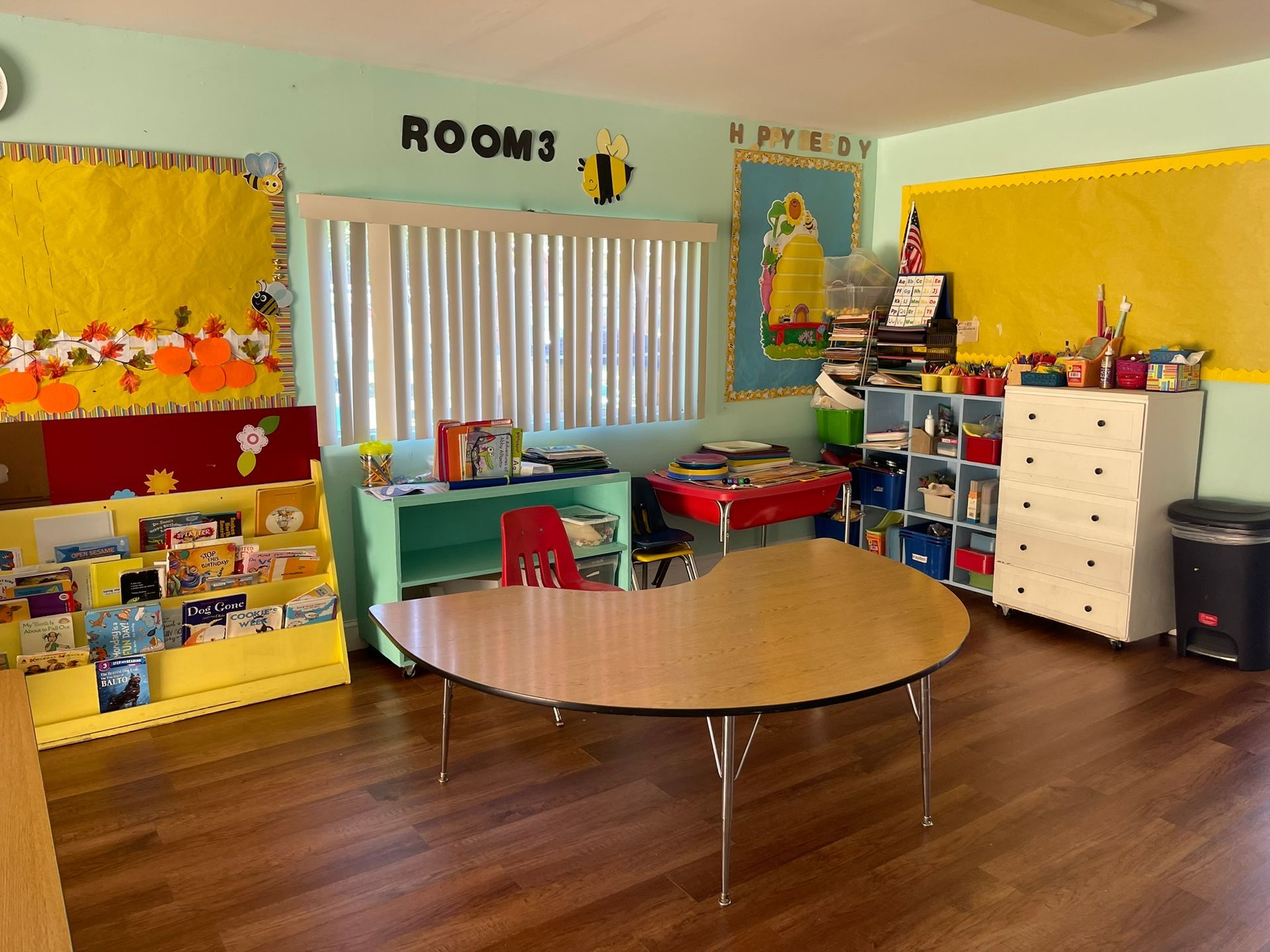 A room with a table and a bulletin board that says rooms on it