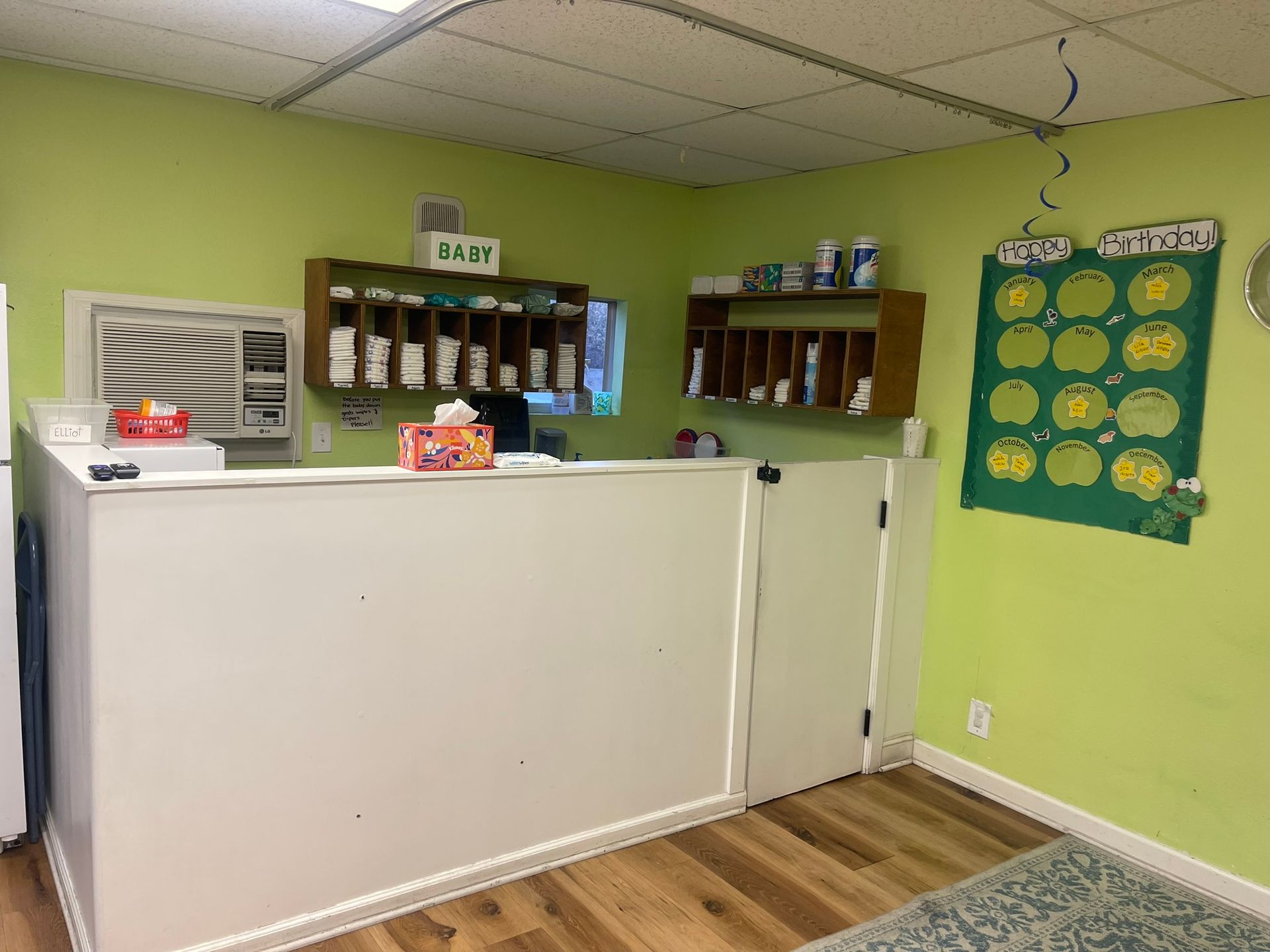 A room with green walls and a white counter.
