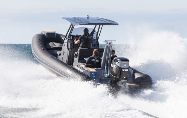 Black speedboat racing across choppy water, spraying white foam under a blue canopy