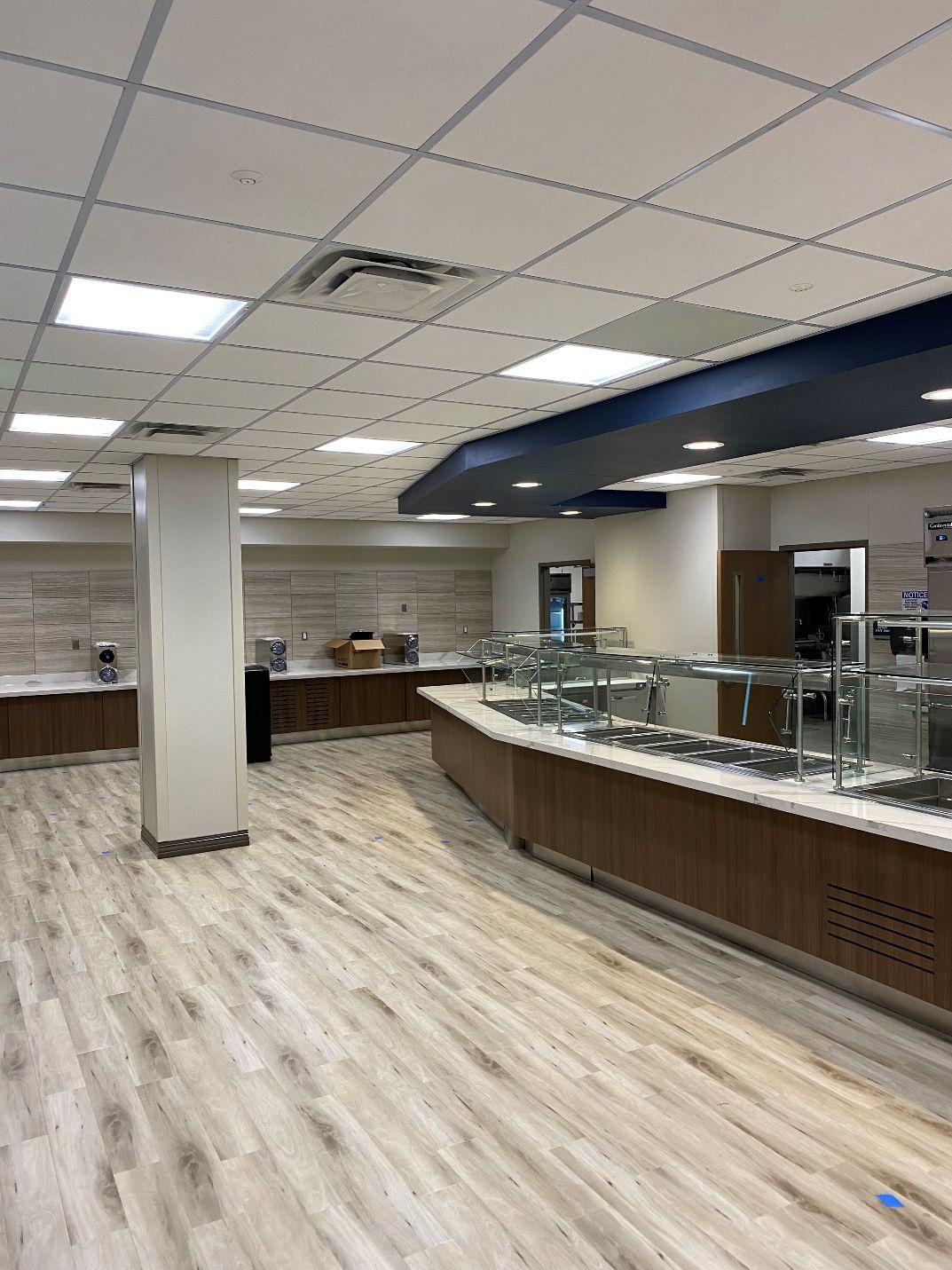 A large room with a buffet line in the middle of it.