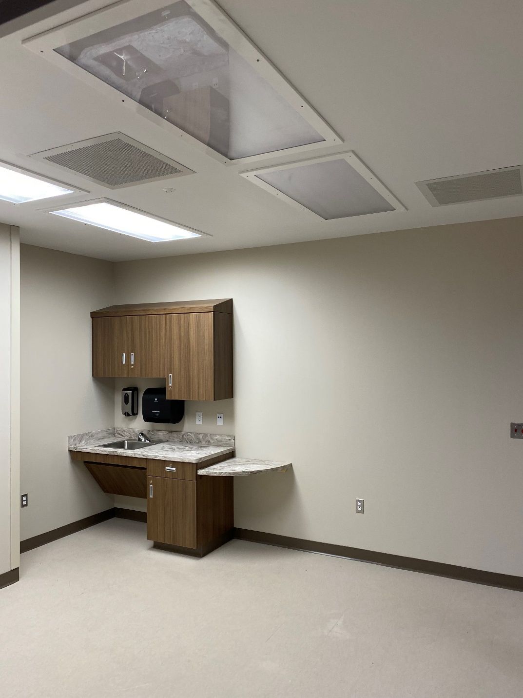 An empty room with wooden cabinets and a sink