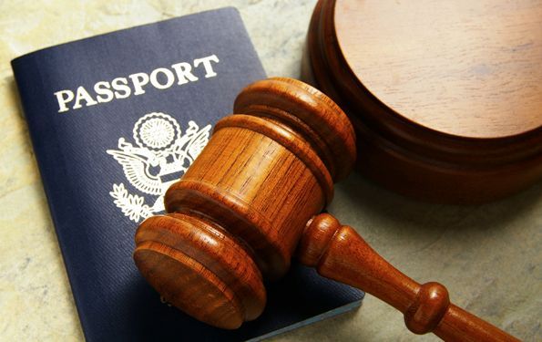 A passport with a wooden gavel next to it.