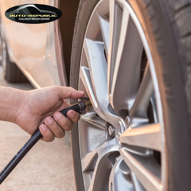 A person is inflating a tire with an auto republic logo in the background