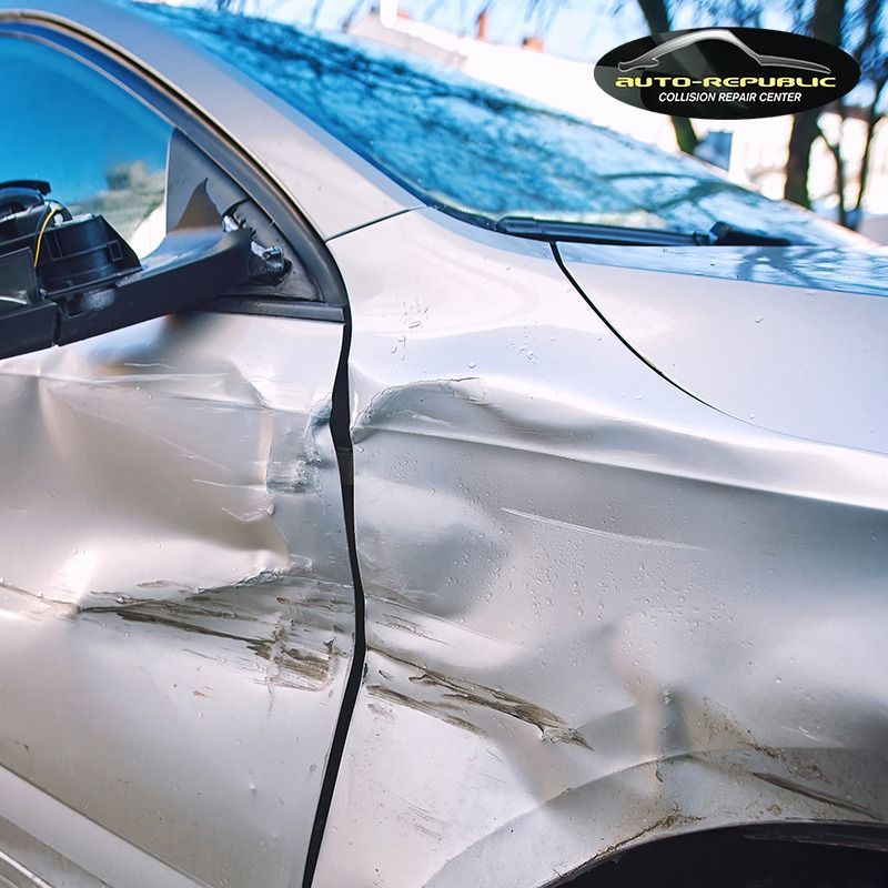 A silver car that has been damaged by a car accident